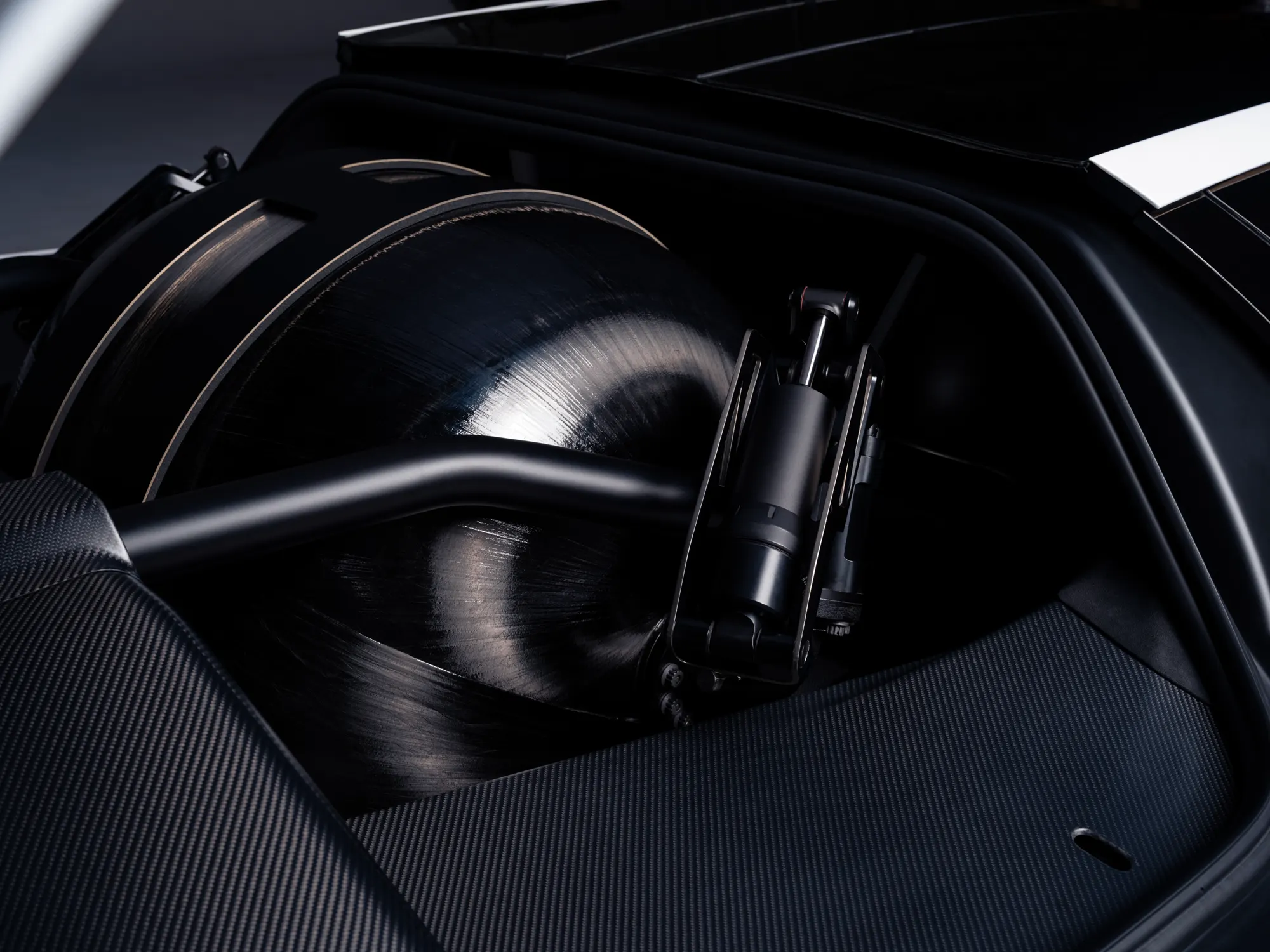 A black wound pressure vessel and an actuator sitting in a carbon-fibre bay.