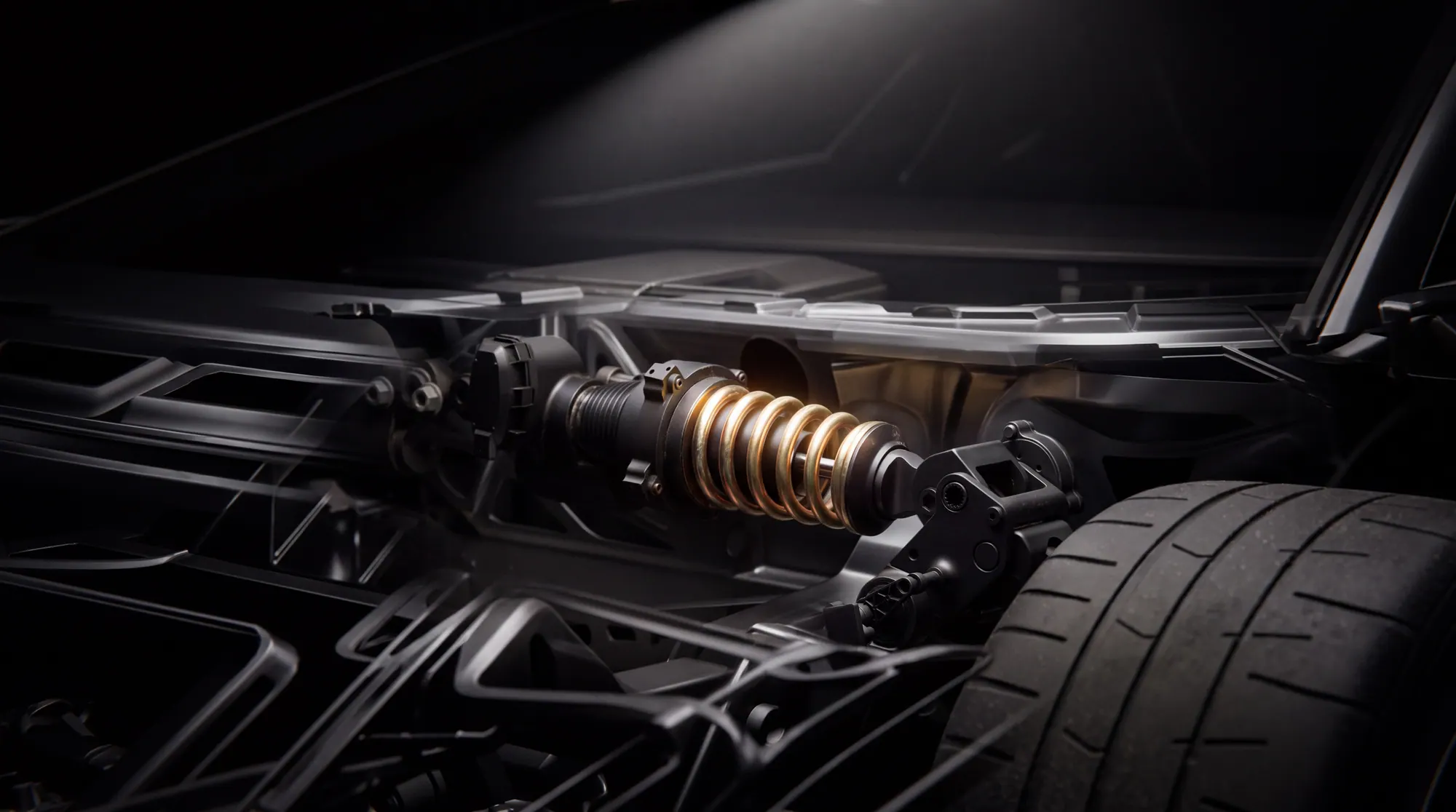 A coil-over damper with a gold spring, mounted in a carbon-fibre bay beside a tyre.